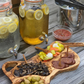 Olive Wood appetizer tray on table with peppers, olives, mushrooms and olives