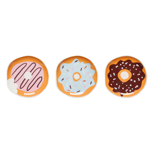 Three round stoneware dishes designed to resemble donuts with different toppings, placed in a row.