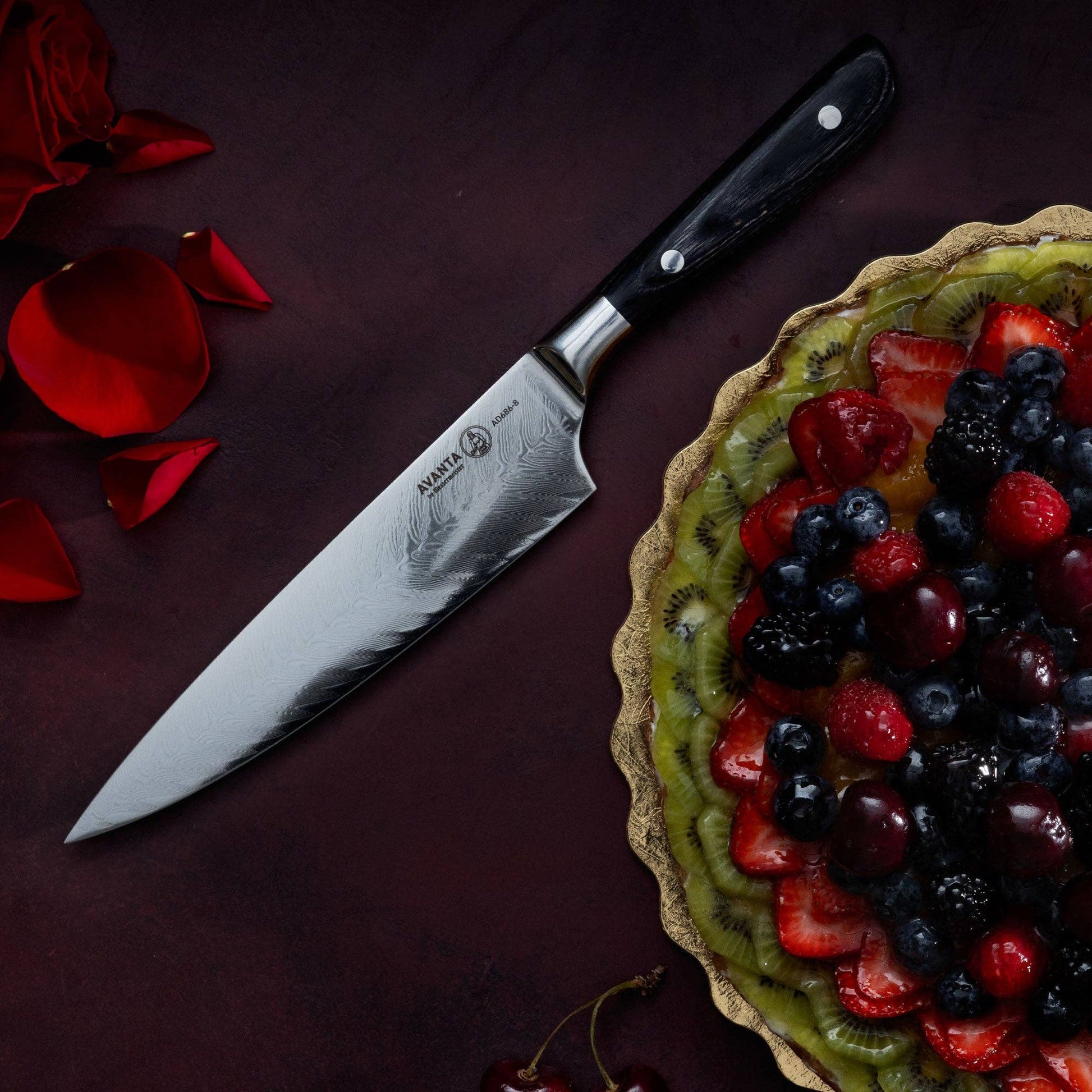 knife on dark red suface with flower a fruit pie and flower. 
