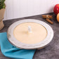 Pie with a pie bird and a metal crust guard on a gray surface with apples and cinnamon sticks in the background