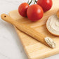 Bagel with cream cheese on a wooden cutting board with tomatoes