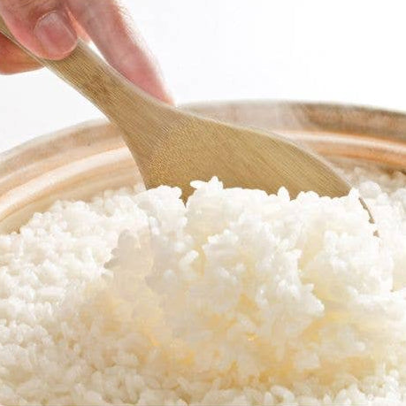 White rice in a bowl with a wooden spoon