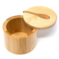 A round bamboo container with a matching lid and a small wooden spoon, shown open on a plain white background.