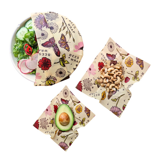 Beeswax wraps with floral designs containing food items on a white background