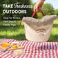 Beige picnic cooler bag with red handles on a checkered blanket outdoors, with text promoting its use for picnics and family trips.