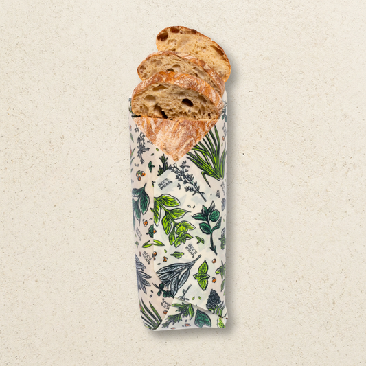 Loaf of bread wrapped in a botanical patterned paper on a beige background
