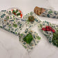 Set of floral-patterned beeswax wraps on a marble surface with fruits and vegetables.