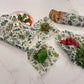 Set of floral-patterned beeswax wraps on a marble surface with fruits and vegetables.