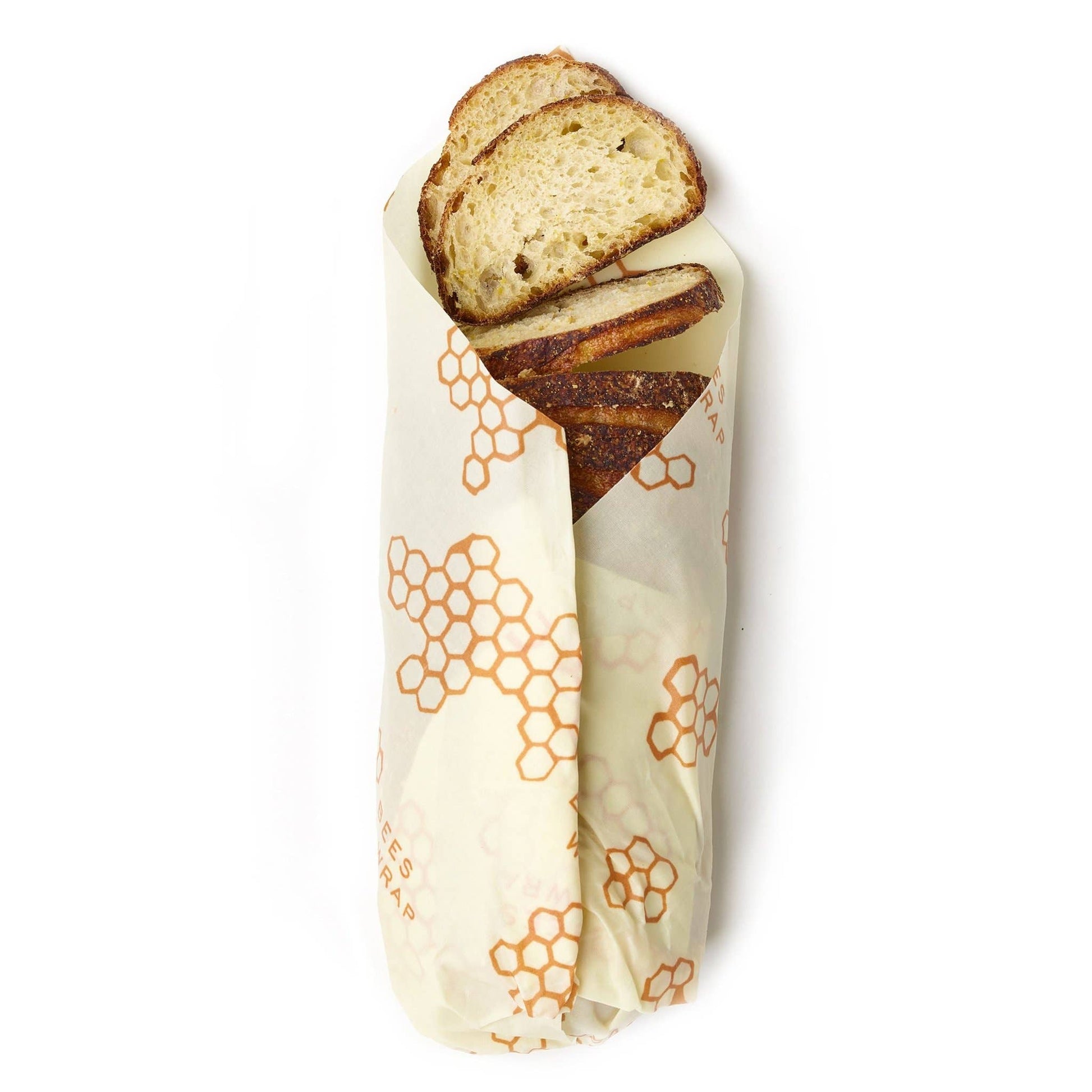 Loaf of bread sliced and wrapped in a beeswax wrap with honeycomb pattern on a white background