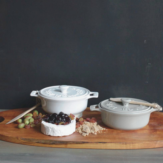 Treat yourself to elevated baked brie with our stylish Brie Bakers, available in white or grey. Each comes with a wooden spatula for serving. Made of stoneware, dimensions are 7" Round x 3" High.