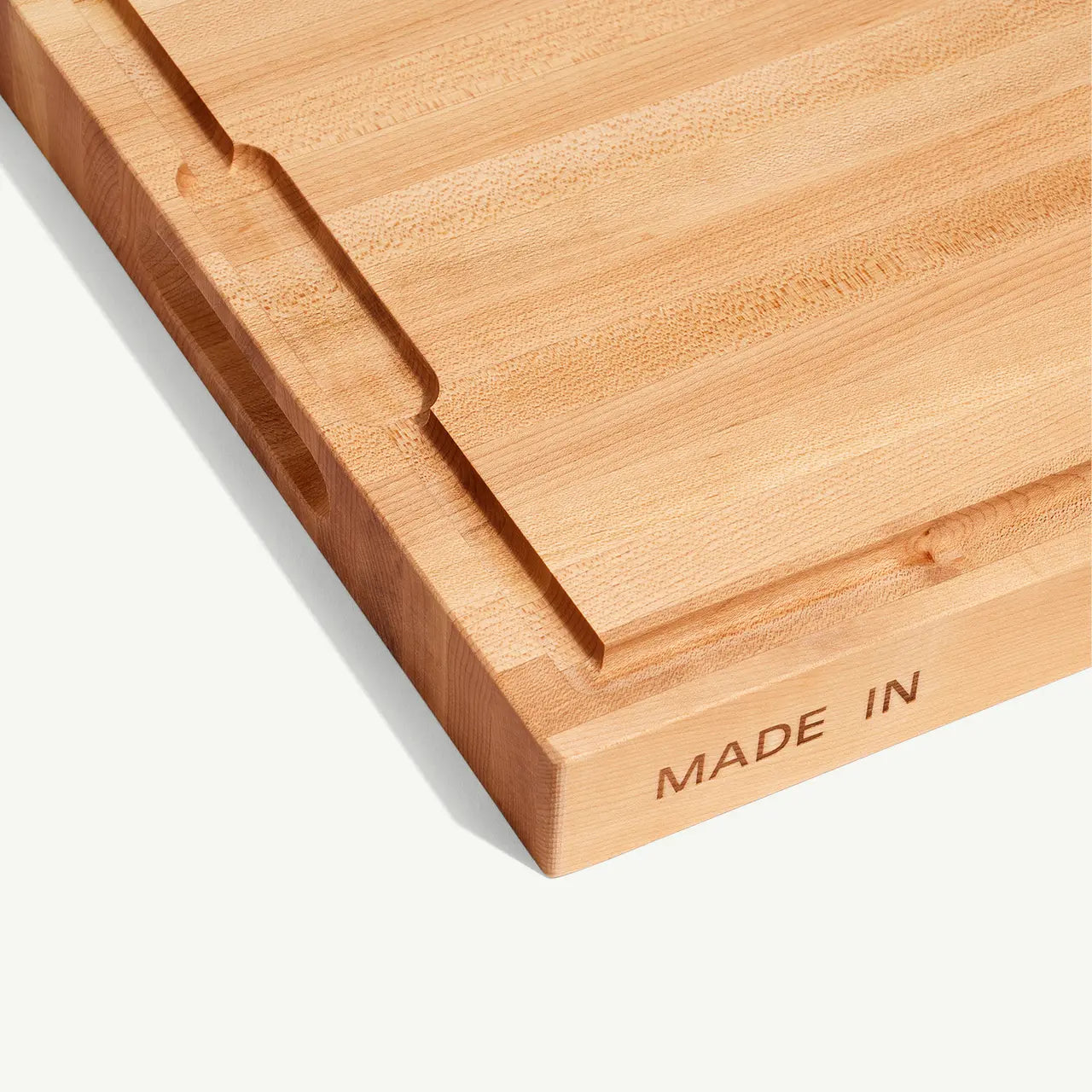 Wooden cutting board with 'MADE IN' engraving on a white background