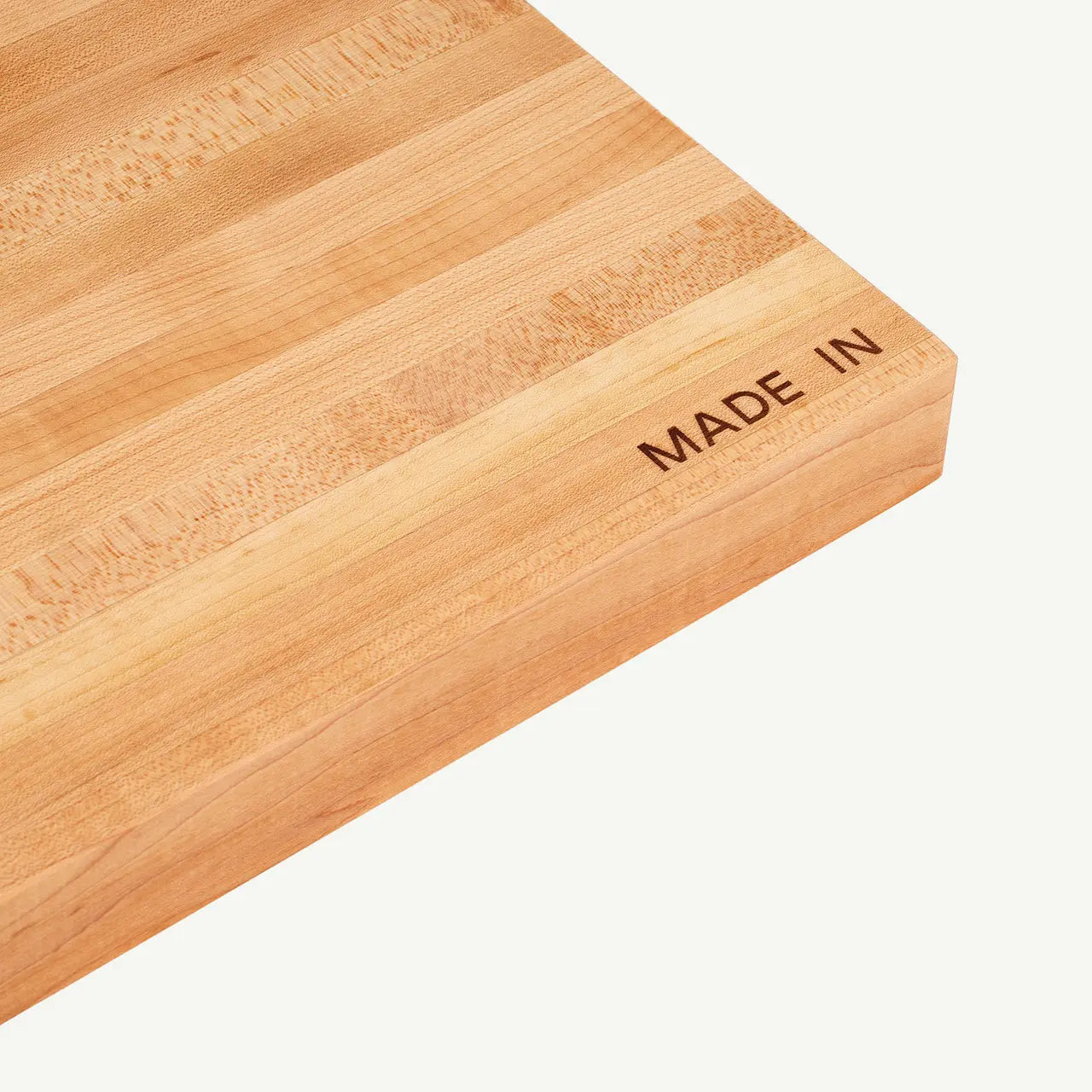 Wooden cutting board with 'MADE IN' engraving on a white background