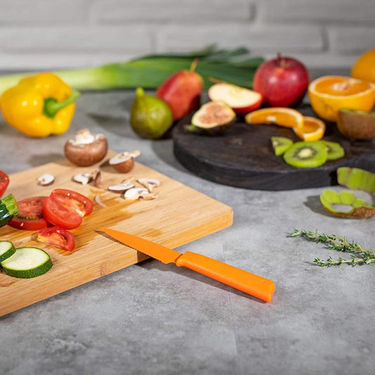 Paring and serrated knife set orange knife cutting vegetables on cutting board