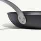 A black carbon steel frying pan with a stainless steel handle, pre-seasoned and ready for use on white background.