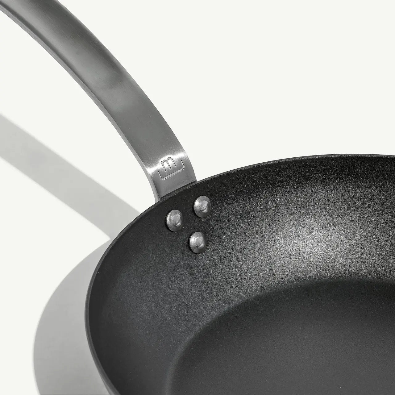 An 8-inch carbon steel frying pan with a gray surface and a stainless steel handle, pre-seasoned and ready for use on a white background.
