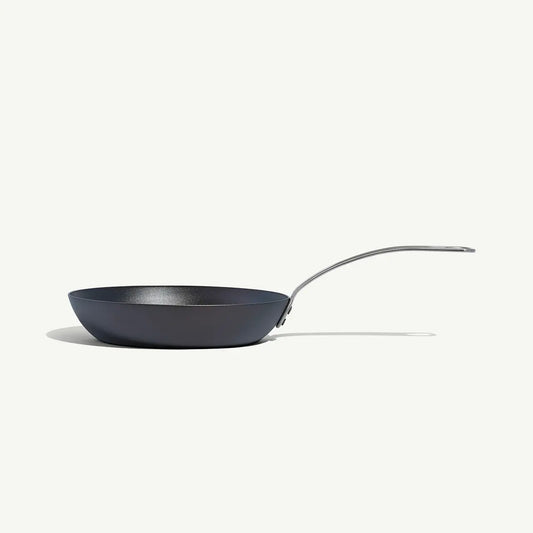 An 8-inch carbon steel frying pan with a gray surface and a stainless steel handle, pre-seasoned and ready for use on a white background.