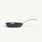 An 8-inch carbon steel frying pan with a gray surface and a stainless steel handle, pre-seasoned and ready for use on a white background.