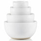 Set of four white ceramic bowls of different sizes stacked on a white background