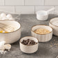 Set of ceramic bowls with kitchen items on a countertop