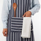 Person wearing a striped apron with a wooden spoon and white towel in the pocket on a white background