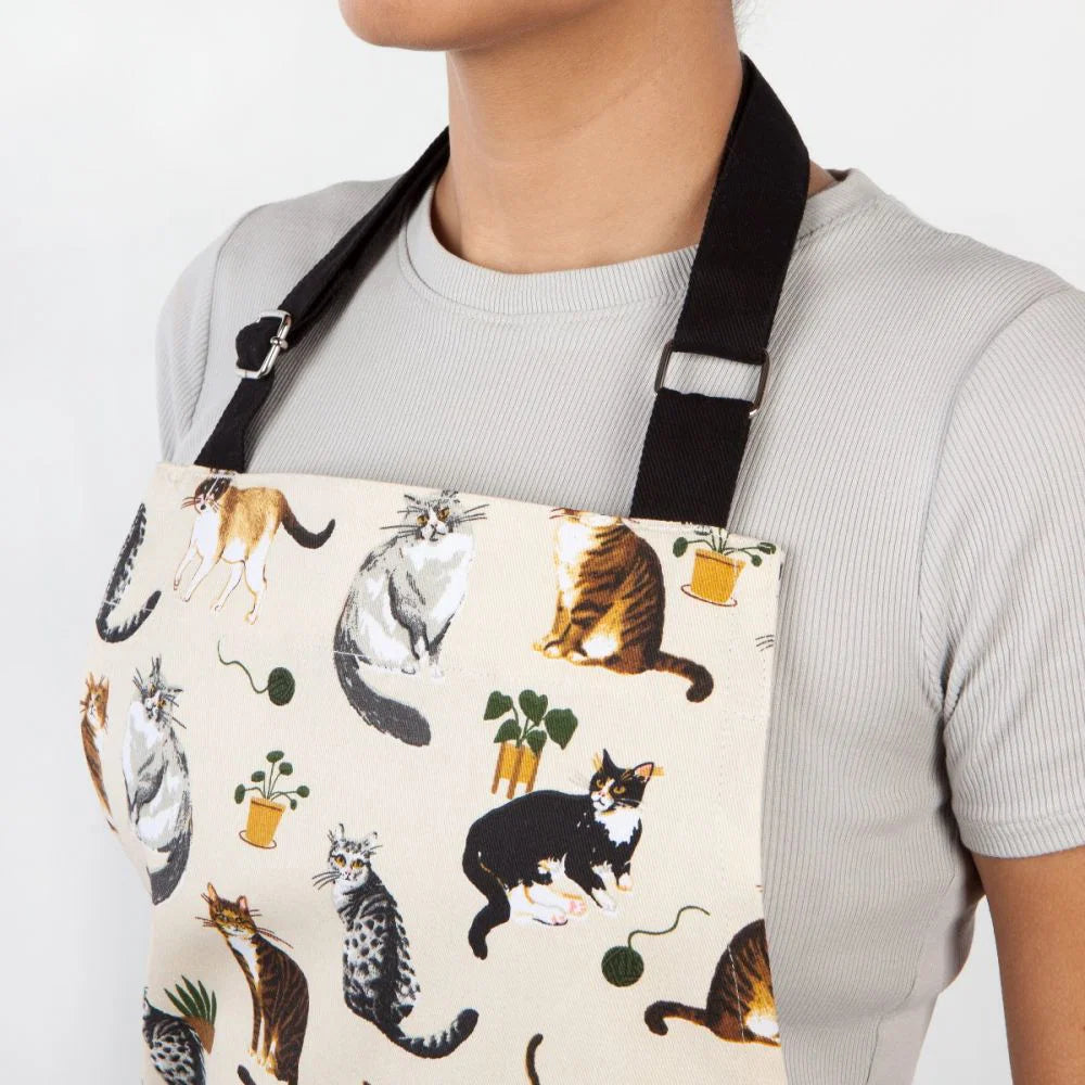Person wearing an apron with cat pattern on a white background