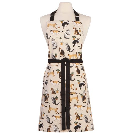 A cream-colored kitchen apron with a black waist tie and neck strap, featuring an all-over print of various cat illustrations in black, brown, and gray. The apron is displayed on a white mannequin torso against a plain white background.