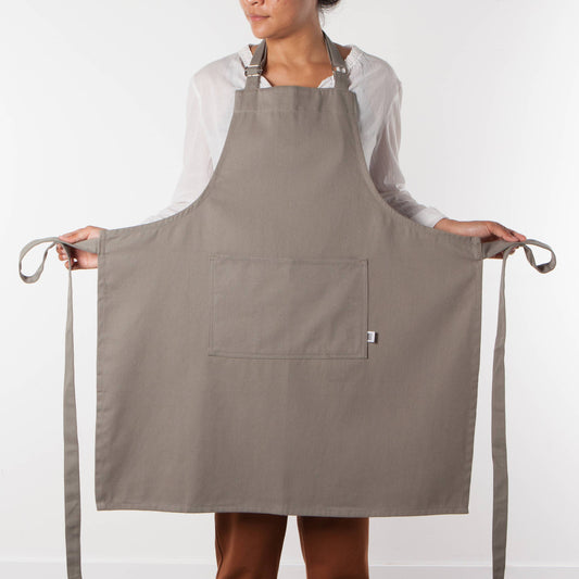 Person wearing a gray apron on a white background