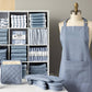 Set of blue kitchen towels, potholders, and an apron displayed on a mannequin against a gray wall.