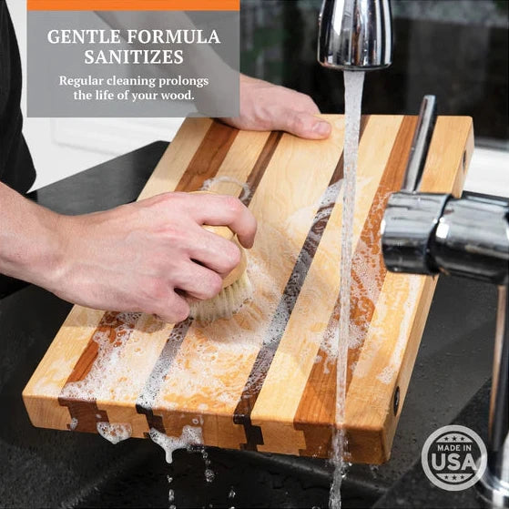 clark's cutting board soap being used on a cutting board in a sink. gentle formula sanitizes regular cleaning prolongs the life of your wood.