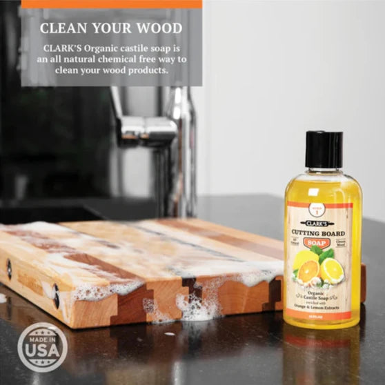 clarks cutting board soap on a counter with a cutting board. clean your wood clark's organic castile soap is an all natural chemical free way to clean your wood products.