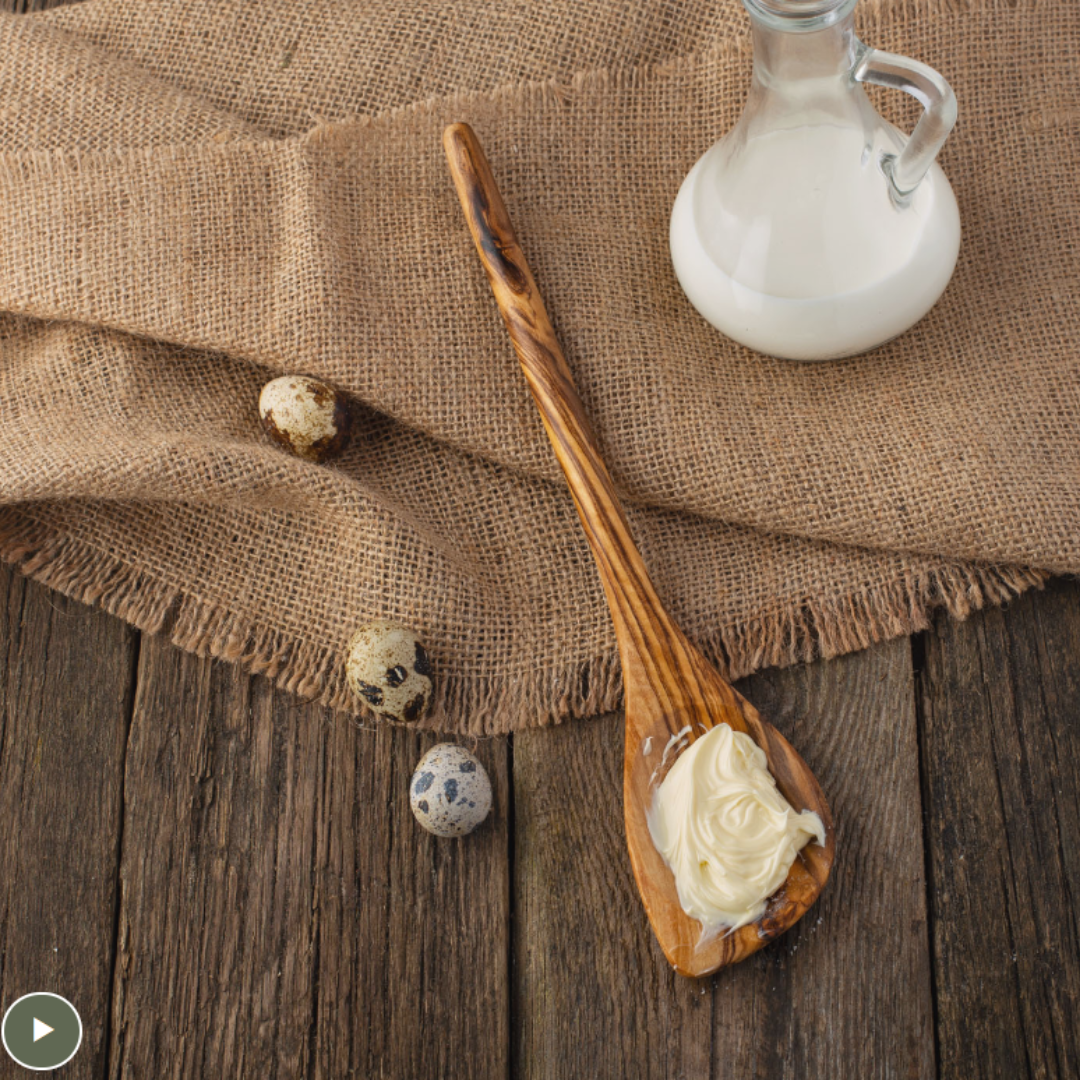 olive wood spoon with pointed end with frosting on a table