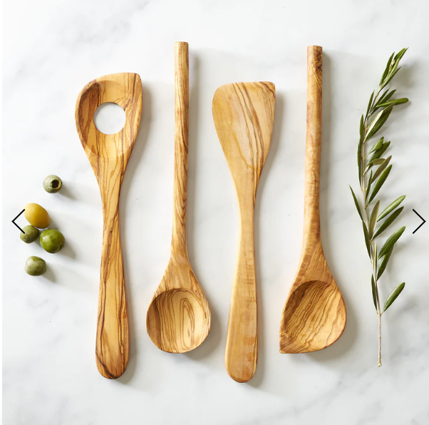 olive wood spoon with pointed end on a counter with other olive wood cooking tools