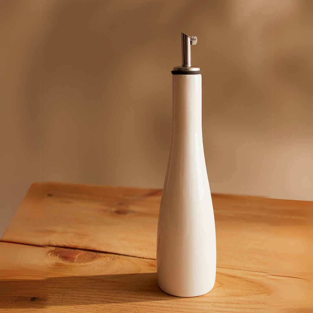 Upgrade your kitchen essentials with Danicas' stylish White Cruet! Its curvy shape and sleek gallery white hue make it a contemporary addition to any kitchen. Perfect for drizzling oils, vinegar, or other liquids on salads and meats, this attractive dispenser features a no-mess stainless steel pouring spout for easy use. 