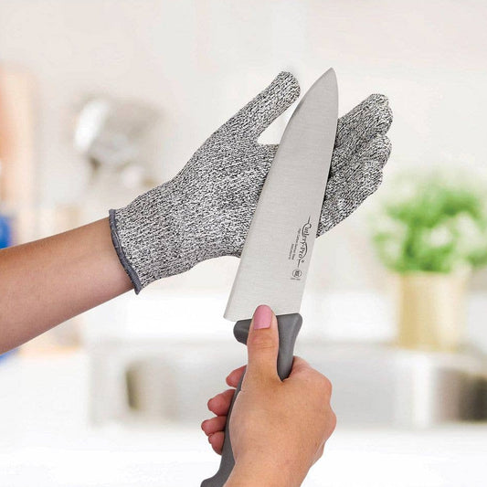 Person holding a knife with a protective glove in a kitchen setting