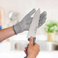 Person holding a knife with a protective glove in a kitchen setting