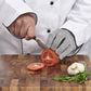Chef cutting tomatoes on a wooden board with protective gloves