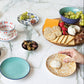 Colorful ceramic plates with various food items on a marble surface