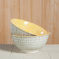Two ceramic bowls with geometric patterns stacked on a wooden surface.