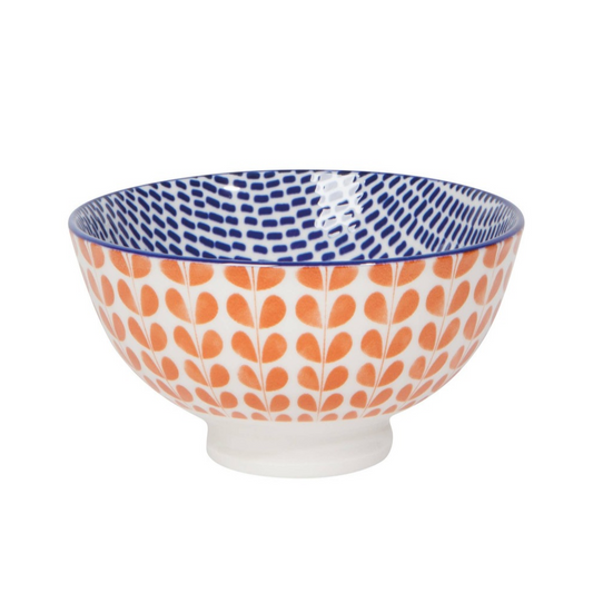white bowl with orange stamped pattern outside and blue stamped pattern on the inside on white background