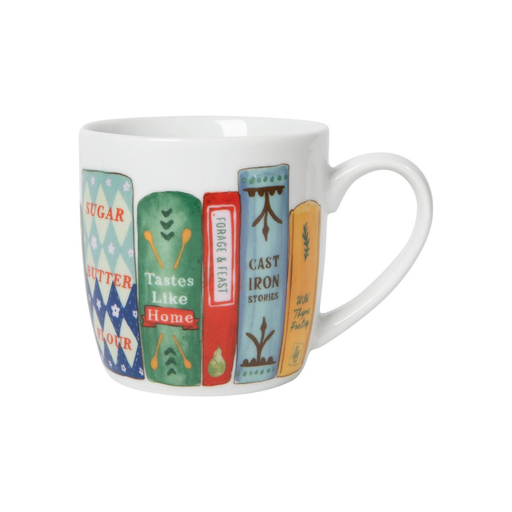 White ceramic mug with colorful cookbooks around the outside on a white background