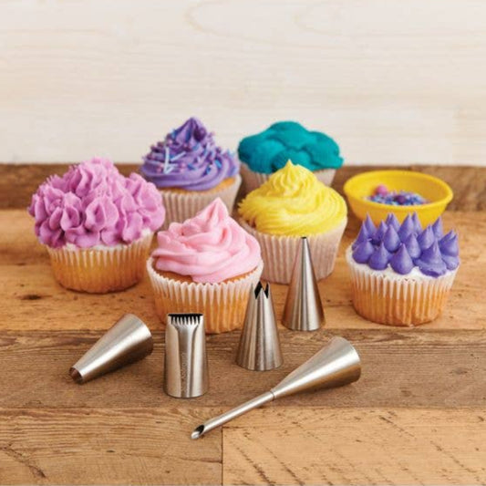 Cupcakes with colorful frosting and piping tips on a wooden surface