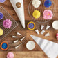 Baking tools and colorful cupcakes on a wooden table