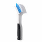Profile view of white dish brush with blue brissels on a white background. 