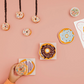 Sweeten up your table with this set of three donut-shaped dishes, featuring pink frosted, blue frosted with sprinkles, and chocolate frosted designs. Whether you're serving appetizers, desserts, or using them as trinket trays, these whimsical plates add a fun-loving touch to any occasion. 