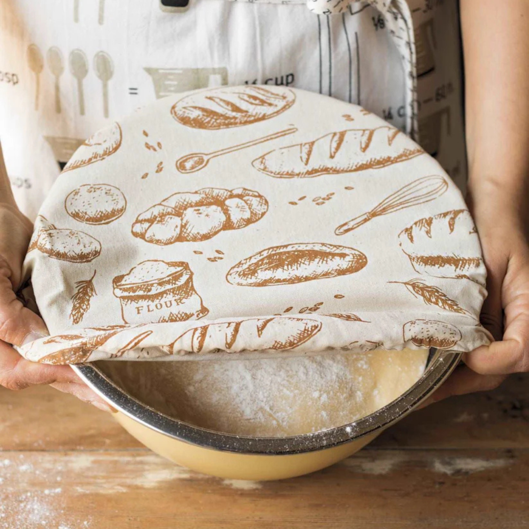 Bowl cover being pulled away from a bowl with dough and flour. 