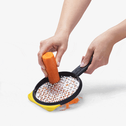 Revamp your kitchen game with Ograte's medium grater! With two sides for versatile use, you'll swiftly grate carrots and zucchini on the bottom with its circular motion blades and efficiently grate cheese on the top with its extra-wide plane. The non-slip foot doubles as a scraper and hooks onto bowls, while the safety cover protects stored blades.