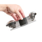Set of metal measuring cups held by a hand on a white background