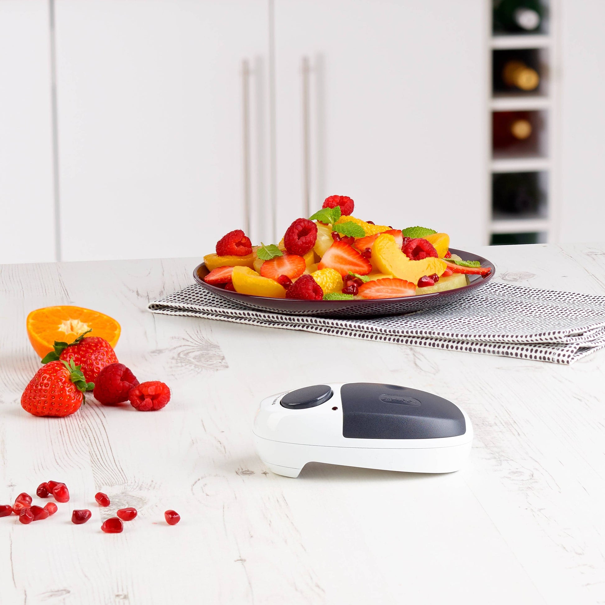 Fruit plate on a kitchen counter with a can opener in the foreground