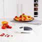 Fruit plate on a kitchen counter with a can opener in the foreground
