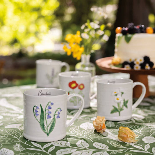 Set of mugs with floral designs on a table outdoors